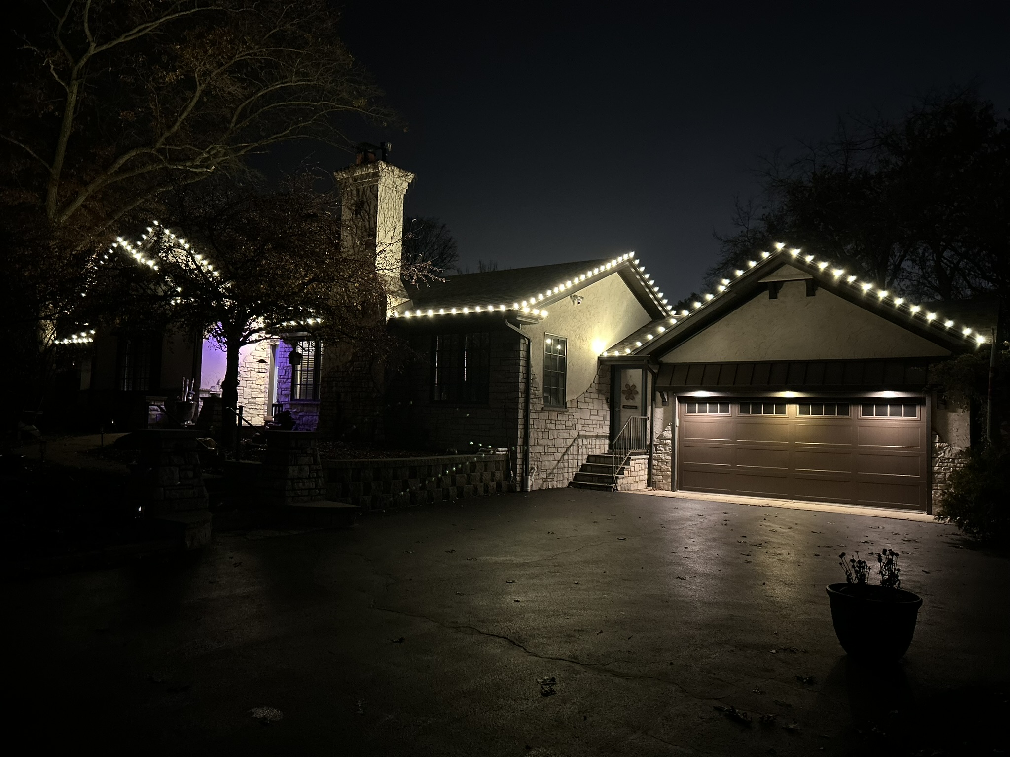 Home with warm white roofline lighting over the garage and entryway